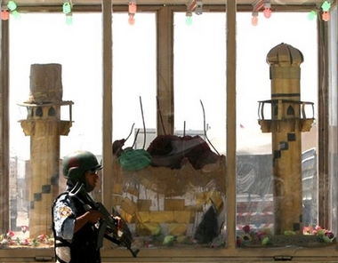 Iraqi policeman passes a model of Samarra's Golden Dome shrine in the Shiite enclave of Sadr City in Baghdad, Iraq, Wednesday, June 13, 2007. Suspected al-Qaida insurgents on Wednesday destroyed the two minarets of the Golden Dome mosque or Askariya Shiite shrine in Samarra, Iraq Wednesday, authorities reported, in a repeat of a 2006 bombing that shattered its famous Golden Dome and unleashed a wave of retaliatory sectarian violence that still bloodies Iraq.