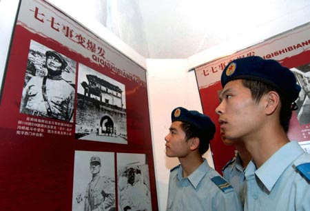 Chinese air force soldiers look at photographs displayed during an activity to mark the 70th anniversary of the July 7 Incident, in Shenyang, Northeast China's Liaoning Province, July 6, 2007. Exactly 70 years ago at Lugouqiao Bridge (Marco Polo Bridge) in suburban Beijing, Japanese aggressors launched an attack against Beijing on July 7, 1937, starting their overall invasion of China.[Xinhua]