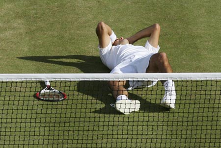 Switzerland's Roger Federer lies on the court after winning the men's singles final against Spain's Rafael Nadal at the Wimbledon tennis championships in London, July 8, 2007. 
