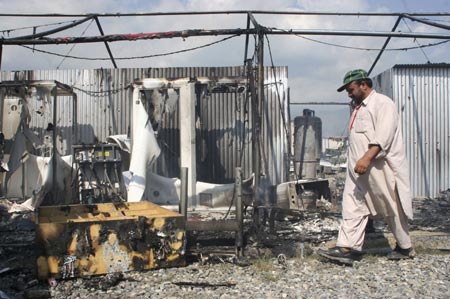 A man walks next to the tented offices of a Western aid agency after it was ransacked by angry protesters in Battagram, 200 km (125 miles) from Islamabad July 10, 2007. The protesters were protesting against an assault by Pakistani force's on the Lal Masjid or Red Mosque. Pakistani forces stormed a mosque compound on Tuesday, killing about 50 militants, as they fought their way through an Islamic school where they believed a rebel cleric was hiding with women and children hostages.