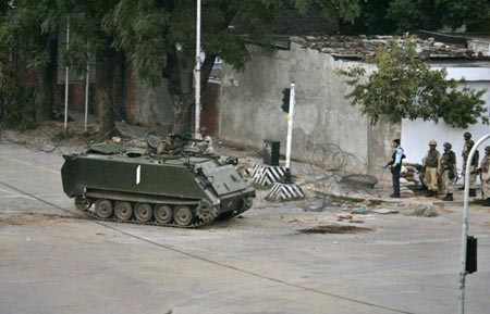 A Pakistani army armoured personnel carrier takes up a position around the Lal Masjid, or Red Mosque, in Islamabad July 10, 2007. Pakistani forces stormed a mosque compound on Tuesday, killing up to 50 militants, as they fought their way through an Islamic school where they believed a rebel cleric was hiding along with women and children.
