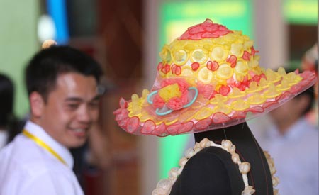 A man looks at an outfit made of condoms at the 4th China Reproductive Health New Technologies & Products Expo in Beijing July 11, 2007. Condoms of all shapes and sizes were on show at a Beijing fashion show on Wednesday featuring dresses, hats and even lollipops made of the said item. [newsphoto] 