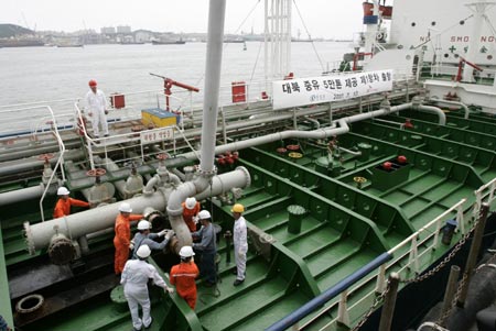 South Korean workers from SK Energy detach loading facilities from South Korean oil tanker 