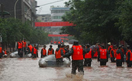 Chinese soldiers evacuate residents from a flooded neighbourhood after a heavy downpour in Southwest China's Chongqing Municipality, July 17, 2007. [Xinhua]