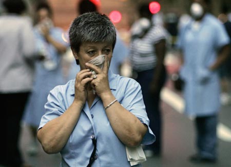 A woman covers her face from steam and smoke at 40th Street and Park Avenue near the scene of an explosion in New York, July 18, 2007. An underground steam pipe exploded in midtown Manhattan on Wednesday, shaking buildings, creating a towering geyser of debris and sending pedestrians fleeing in scenes reminiscent of the Sept. 11 attacks.