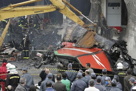 A crane removes the tail section of a TAM airlines Airbus A320 that slid off the runway of Congonhas airport and into a building before it exploded in fire, in Sao Paulo July 18, 2007. The Brazilian airliner crashed and burst into flames on Tuesday at Brazil's busiest airport, and as many as 200 people were feared dead in the country's second major air disaster in less than a year. 