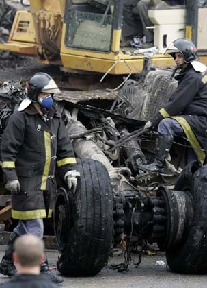 Firemen tie to a crane the undercarriage of a TAM airlines Airbus A320 that slid off the runway of Congonhas airport and into a building before it exploded in fire, in Sao Paulo July 18, 2007. The Brazilian airliner crashed and burst into flames on Tuesday at Brazil's busiest airport, and as many as 200 people were feared dead in the country's second major air disaster in less than a year.