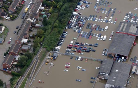 An aerial view shows flood water in Tewkesbury, in central England July 22, 2007. Torrential rain caused flash floods and brought transport chaos, the Highways Agency said on Saturday. As many as 2,000 people had to be taken to emergency centres in the Cotswolds, one of England's most picturesque regions. 