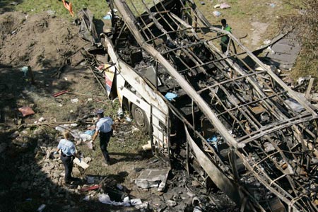 Rescue workers search wreckage of a coach carrying Polish pilgrims plunged down a hillside and burst into flames at Vizille near the southeastern French city of Grenoble, July 22, 2007. At least 24 died and as many seriously injured in the vehicle which crashed through a barrier after a steep hill and came to rest on the banks of the river Romanche and burst into flames.