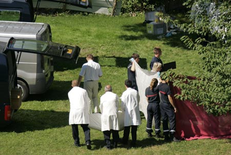 Rescue workers remove bodies from scene where a coach carrying Polish pilgrims plunged down a hillside and burst into flames at Vizille near the southeastern French city of Grenoble, July 22, 2007. At least 24 died and as many seriously injured in the vehicle which crashed through a barrier after a steep hill and came to rest on the banks of the river Romanche and burst into flames.