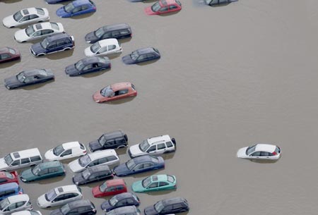 An aerial view shows flood water in Tewkesbury, in central England July 22, 2007. Torrential rain caused flash floods and brought transport chaos, the Highways Agency said on Saturday. As many as 2,000 people had to be taken to emergency centres in the Cotswolds, one of England's most picturesque regions. 