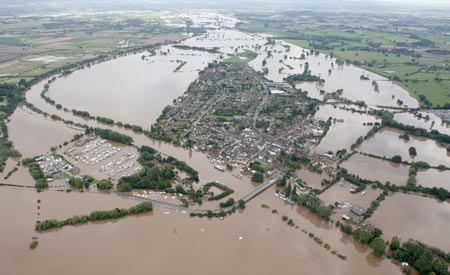 An aerial view shows flood water around Upton upon Severn, in central England July 22, 2007. Torrential rain caused flash floods and brought transport chaos, the Highways Agency said on Saturday. As many as 2,000 people had to be taken to emergency centres in the Cotswolds, one of England's most picturesque regions. 