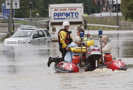 Firemen rescue residents in Tewkesbury, Gloucestershire, July 22, 2007. Torrential rain caused flash floods and brought transport chaos, the Highways Agency said on Saturday. As many as 2,000 people had to be taken to emergency centres in the Cotswolds, one of England's most picturesque regions. 