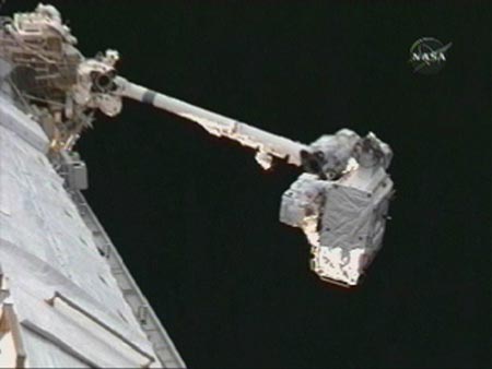 Flight engineer Clayton Anderson holds the early ammonia servicer unit as he is moved into position on the International Space Station's robot arm as he prepares to jettison the refrigerator sized hardware into space July 23, 2007. 