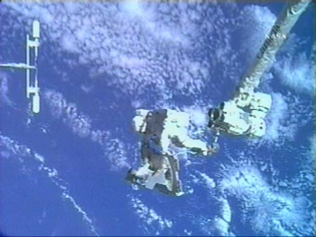 Flight engineer Clayton Anderson prepares to jettison video stanchion frame while attached to the International Space Station's robot arm July 23, 2007. The spacewalking pair will install a televison camera stanchion and jettison a 1,400-pound Early Ammonia Servicer during the planned 6 hour-plus spacewalk.[Reuters]
