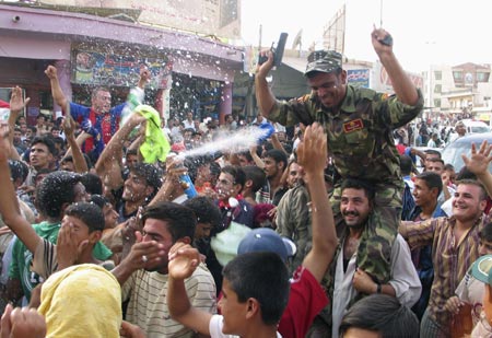 Residents celebrate the victory of Iraq's soccer team over South Korea during the semi-final of the 2007 AFC Asian Cup soccer tournament, in Kut, 172 km (107 miles) south of Baghdad, July 25, 2007. 