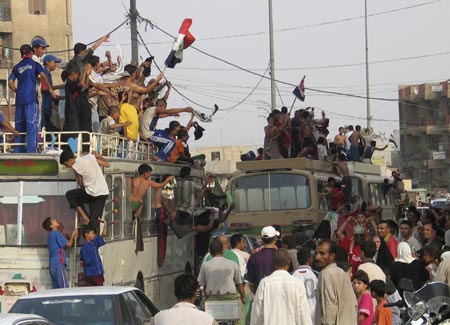 Residents celebrate the victory of Iraq's soccer team over South Korea during the semi-final of the 2007 AFC Asian Cup soccer tournament, in Najaf, 160 km (99 miles) south of Baghdad, July 25, 2007. 