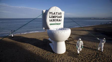 Greenpeace activists take part in a protest against the unloading of residual water into the sea and pollution of beaches at Los Muertos beach in Puerto Vallarta, Jalisco, August 1, 2007. The words on the blown up model of a toilet bowl reads, 