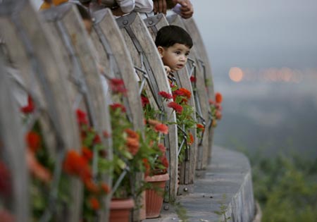 One-year-old Danyal Khan looks at Pakistan's capital Islamabad from the Daman-E-Koh viewpoint on July 31, 2007. 