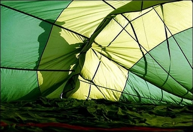 A person works on a hot air-balloon prior to taking off in a field near the Chambley-Bussieres air base, eastern France, during the 