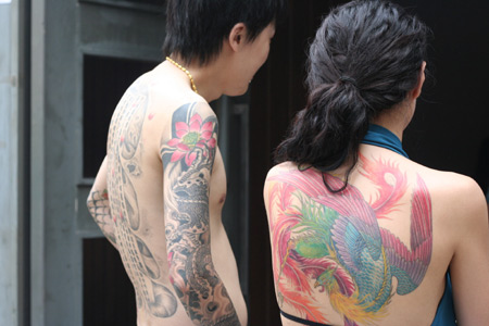 A man and a woman show their tattoos during the Tattoo Show Convention China
