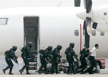 Members of the Indonesian police elite anti-terrorist unit take part in a drill at Sukarno-Hatta airport in Jakarta July 31, 2007.