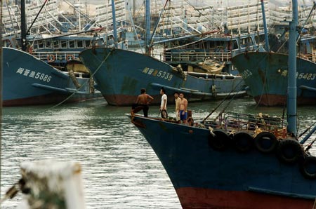 Chinese fishermen rest on a ship anchored at a harbour as the tropical storm Wutip weakens to a tropical depression in Putian, East China’s Fujian Province August 9, 2007. Wutip, meaning 'butterfly', is set to unleash gales and rain in Fujian and neighboring Zhejiang province from late Thursday through to Friday, Xinhua News Agency reported. [Xinhua]