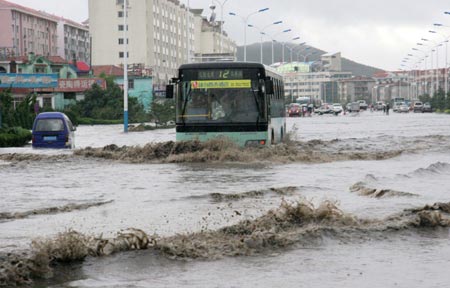Vehicles drive through a flooded street after heavy rains in Weihai, East China’s Shandong Province, August 10, 2007. [Xinhua]