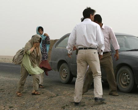 Two South Korean female hostages are escorted after their release in Arzoo of Ghazni province, southwest of Kabul August 13, 2007. Taliban insurgents in Afghanistan freed two South Korean women hostages on Monday and handed them over to the Red Crescent, Reuters witnesses said.[Reuters]