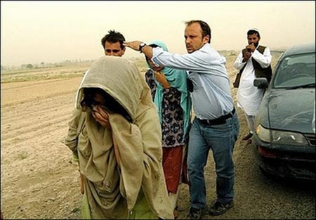 A man from ICRC puts his hand in front of the cameras in Ghazni, as the two South Korean hostages freed by the Taliban walk by. 