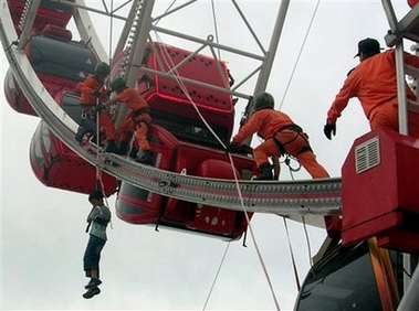South Korean firefighters rescue a student from a car of a Ferris wheel at the World Carnival Busan, south of Seoul, Monday, Aug. 13, 2007.[AP]