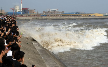 People watch tidal waves along Qiantang River