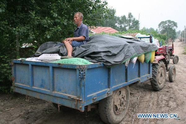 Villagers evacuate before the rainstorms come in Nong'an County near Changchun, capital of northeast China's Jilin Province, Aug. 4, 2010. Thousands evacuated as more rainstorms hit Jilin