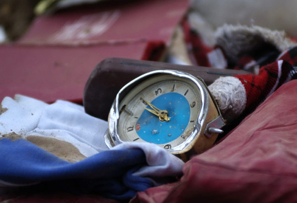 Personal items lie amid muddy ruins