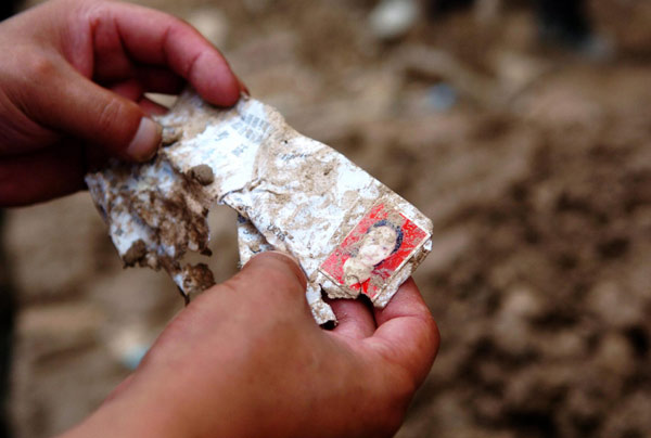 Personal items lie amid muddy ruins