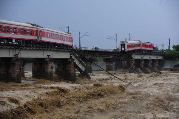 Train cars fall into river in SW China, no injuries