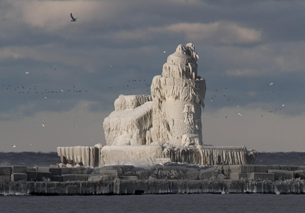 Ice-covered lighthouse bathed by sunlight