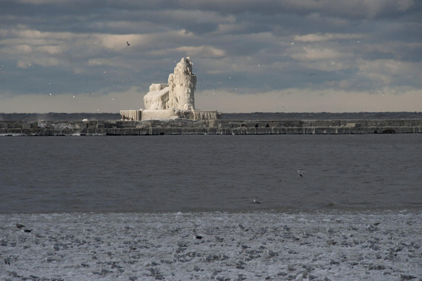 Ice-covered lighthouse bathed by sunlight