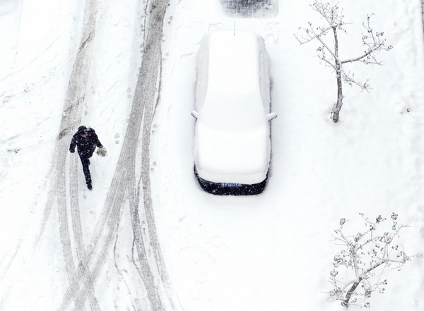 A pedestrian walks on a snow-covered path in a residential area in downtown Urumqi, capital of Northwest China's Xinjiang Uygur autonomous region, April 4, 2011. Heavy snow hits Urumqi