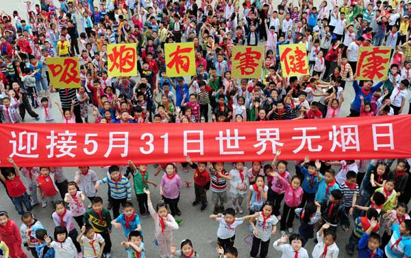 Students from Xiaoxiang Primary School in Yantai city, East China’s Shandong province, lift a banner on May 30, reading “Welcome World No-Tobacco Day on May 31”, as well as six posters warning in Chinese, “Smoking is harmful to health”.[ Students reject tobacco in E China