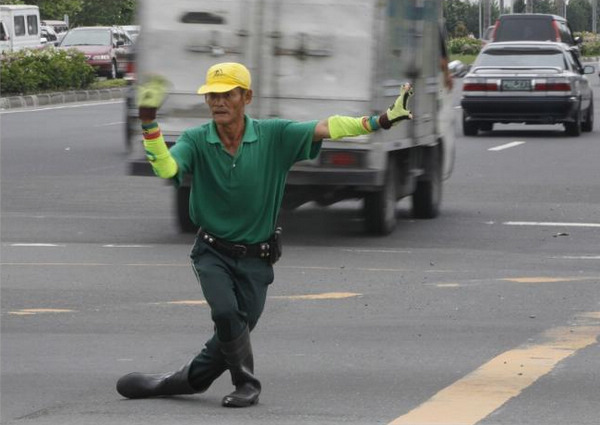 A combination picture shows Ramiro Hinojas, 46, a dancing traffic cop giving directions to vehicles along a busy street of Manila June 10, 2011. Dancing traffic cop