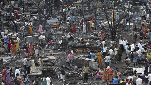 Residents stand amidst their destroyed dwellings leveled by a fire at the Tondiapet slum in the southern Indian city of Chennai June 17, 2011. About 300 huts were gutted in the fire but no casualties were reported, a fire official said on Friday. The cause of the fire was unknown. Fire guts 300 huts in India