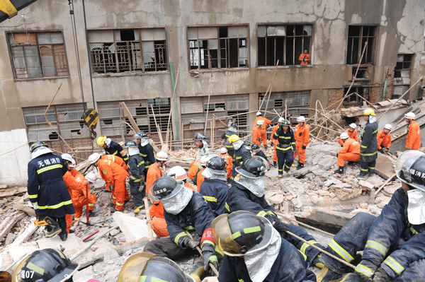 Firefighters look for signs of life in the rubble of a building that collapsed in Huishan district, Wuxi, Jiangsu province, on Sunday morning, June 19, 2011. The collapse buried 16 people. Six of them were treated in hospital. The cause of the accident is being investigated. Building collapse buries 16 in East China city
