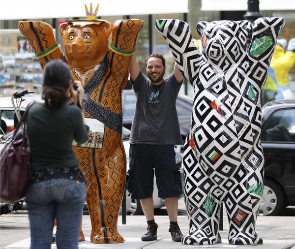 Tourists take happy snaps at Buddy Bear sculptures at the Kurfuerstendamm boulevard in Berlin July 12, 2011. Buddy Bear sculptures on displayed in Berlin