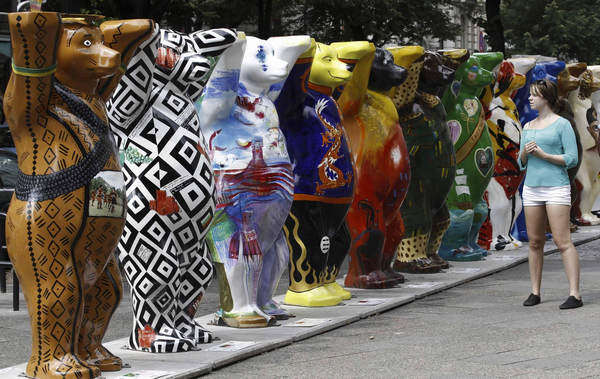 A woman looks at Buddy Bear sculptures at the Kurfuerstendamm boulevard in Berlin July 12, 2011. Buddy Bear sculptures on displayed in Berlin