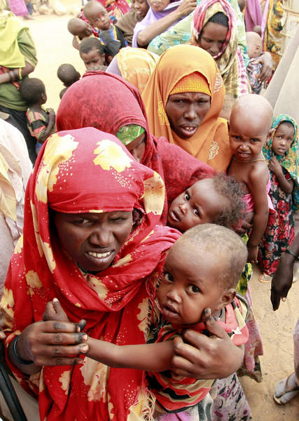 Internally displaced women carry their malnourished children as they queue at a mobile medical facility at the Hiran IDP settlement in Galkayo, northwest of Somalia's capital Mogadishu, July 18, 2011. Displaced Somalis suffer from malnutrition