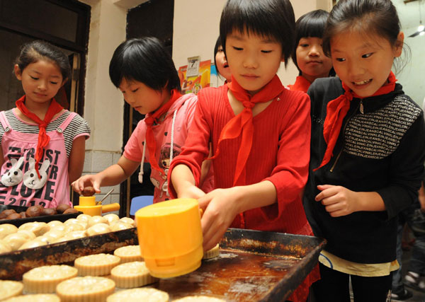 Children learn to make festival delicacy