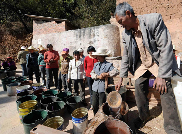 Zhang Xuexian distributes water at Zhangjiacun village in Chuxiong Yi autonomous prefecture, Southwest China’s Yunnan province, Feb 8, 2012. Weekly Photos: Feb 6 - 12