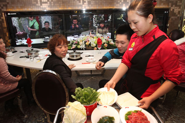 Customers at a hot pot restaurant in Beijing have dinner with their friends in Shanghai by video, Feb 9, 2012. The service was launched by the restaurant early this month. Weekly Photos: Feb 6 - 12