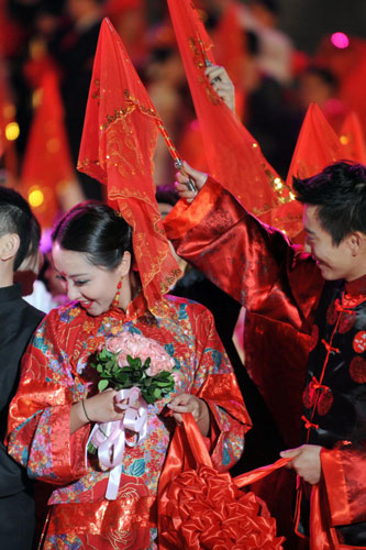 A groom uncovers the bridal veil during a group wedding ceremony in Hangzhou